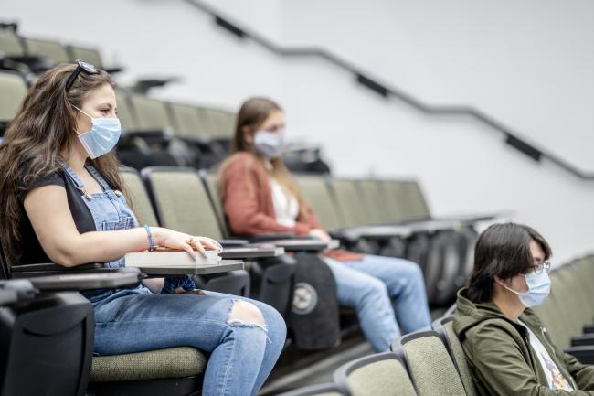 Two students sitting in class wearing masks