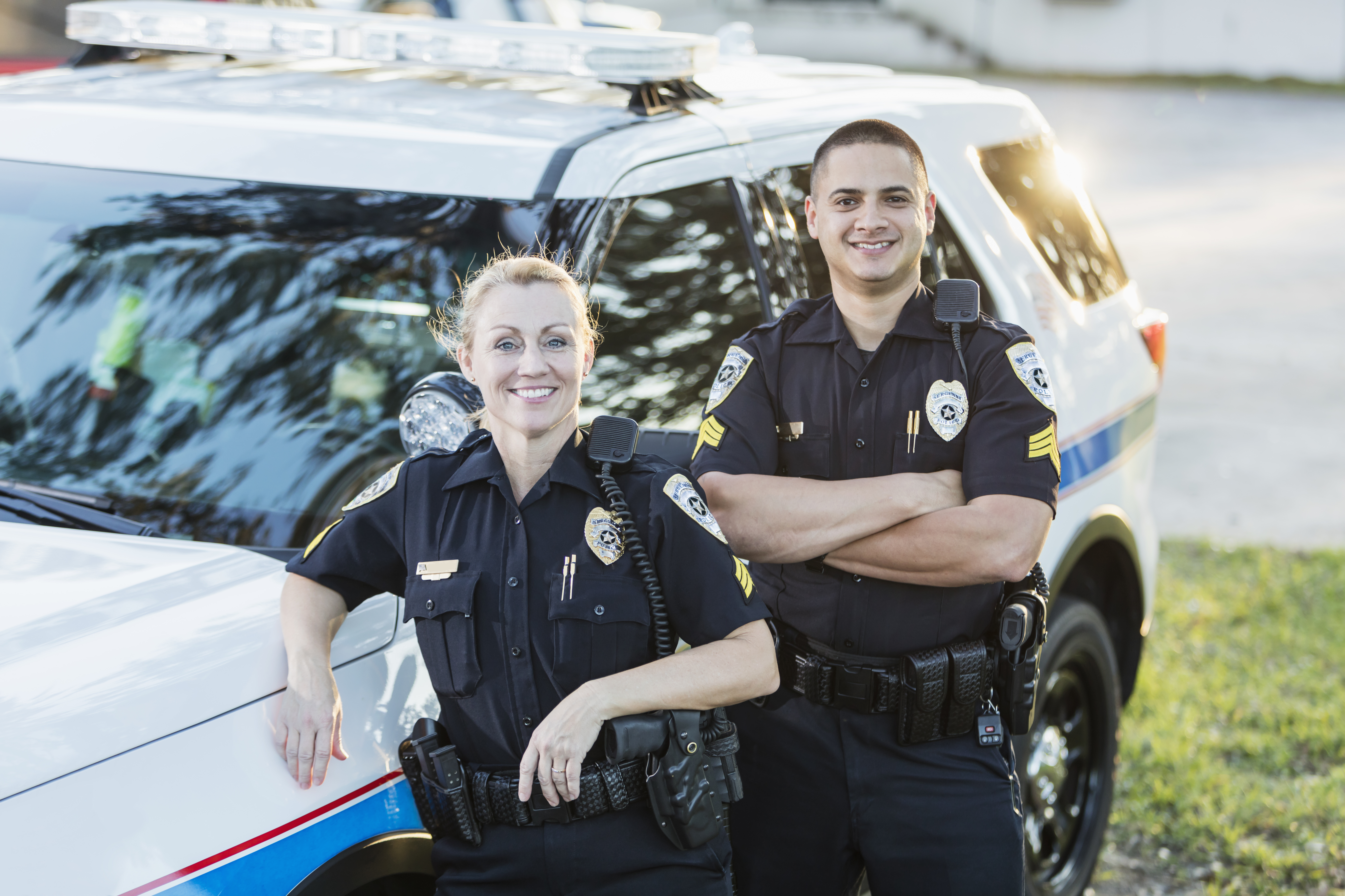 2 female cops posing next to car