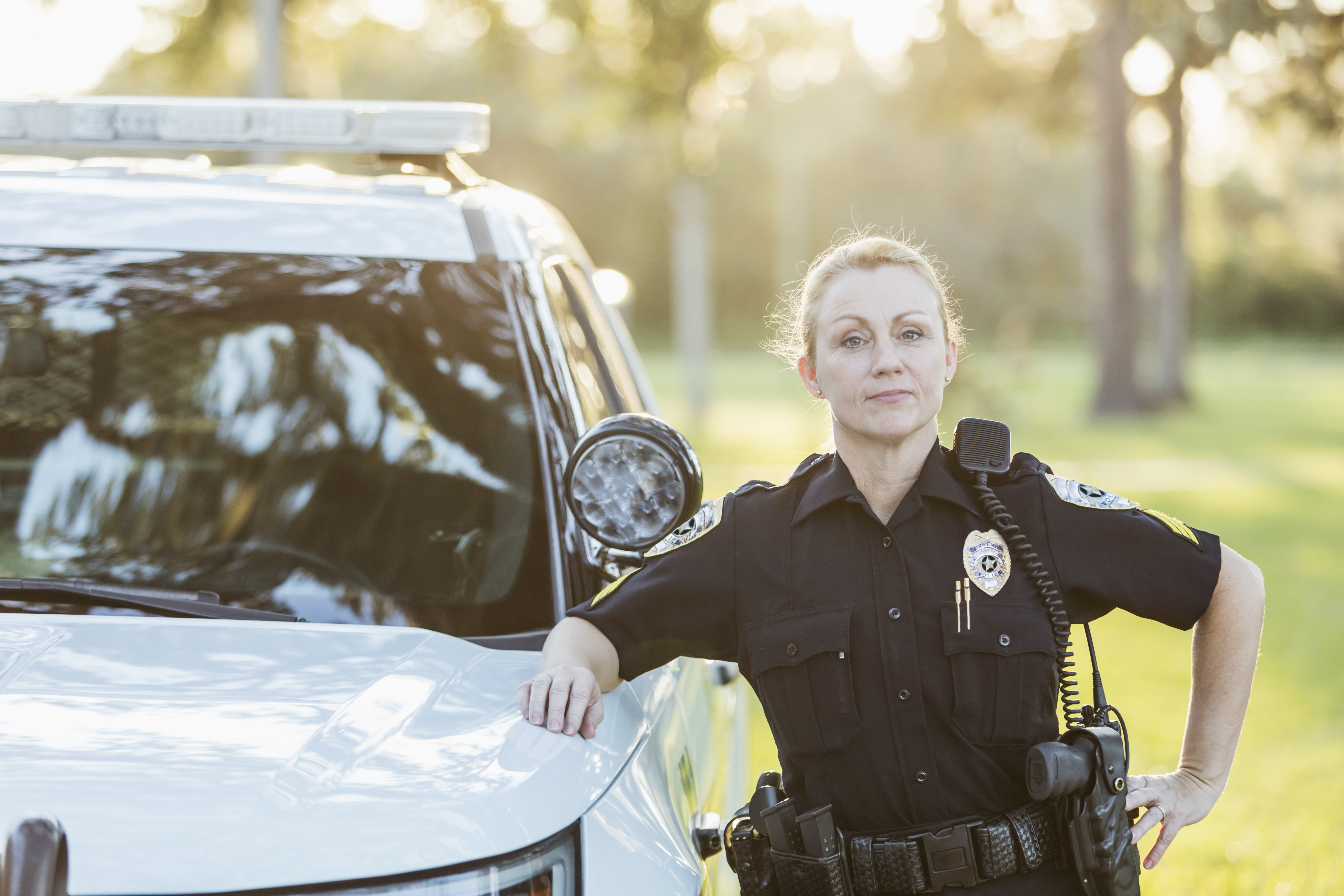 Female cop posing on car