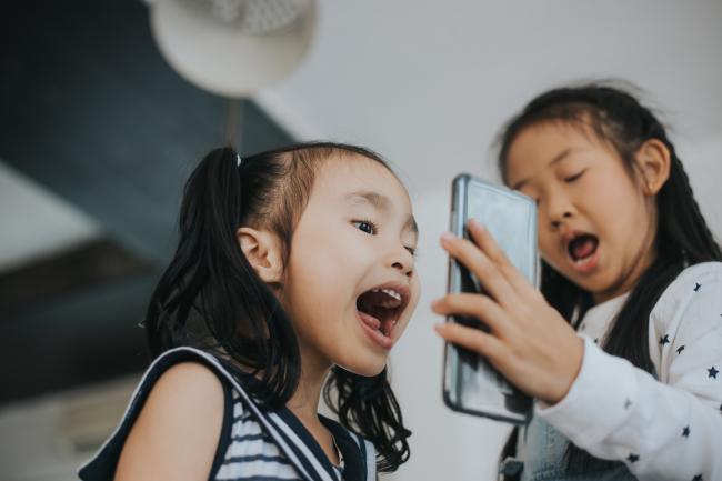 Two little girls excited, FaceTiming on cell phone